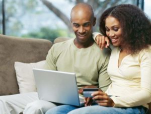 A happy couple using laptop