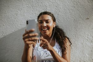 A woman video-calling and smiling using handsfree