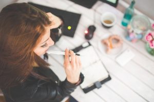 Business woman sitting at a desk with a planner and morning breakfast after looking into title loans in Brattleboro